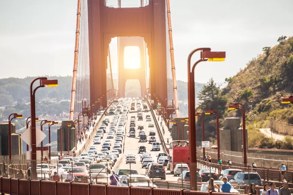 View of traffic on Golden Gate Bridge at sunset.
